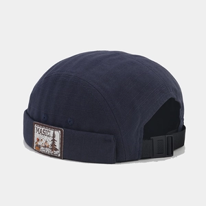 Detail view of navy miki hat showing retro patch and adjustable strap with plastic buckle
