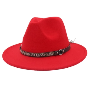Detail of red fedora hat with ethnic patterned ribbon and metallic ring buckle