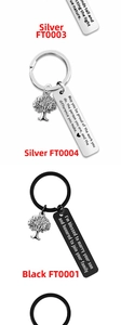 Detail of stainless steel keychains with tree of life charms and engraved metal plates