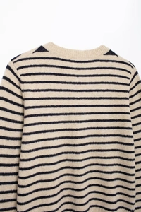 Close-up of the round neckline and striped knit texture on this beige wool blend sweater