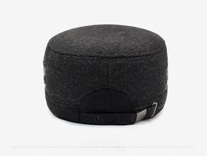 Detail view of the back of a dark grey wool flat cap showing the metal adjustment buckle