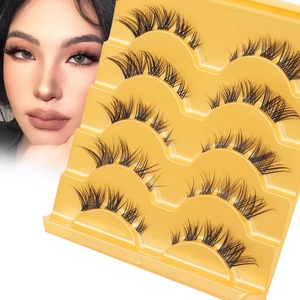Detailed view of 5 pairs of black feathered false eyelashes on a yellow tray with model effect