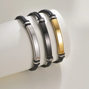 Drei geflochtene schwarze Lederarmbänder mit Platten aus Silber, Schwarz und Goldstahl