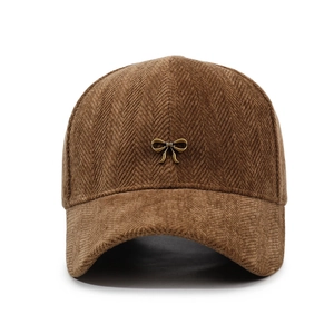Brown corduroy baseball cap with golden bow metal detail and textured herringbone pattern