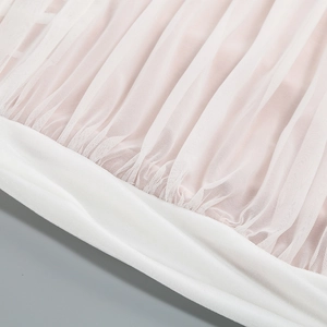 Close-up of pleated white and pink tulle fabric with delicate mesh texture details