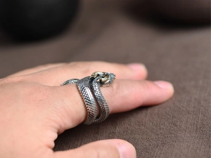 Close-up of vintage silver snake ring with gold accents and detailed scale texture
