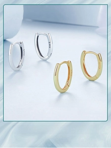 Macro detail of oval hoop earrings in silver and gold with S925 hallmark engraving