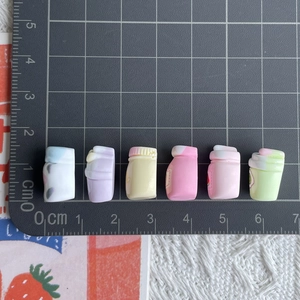 Miniature colorful resin juice bottles shown with a ruler for size measurement