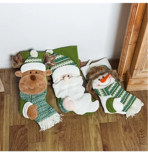 Detail of green knitted Christmas stockings featuring 3D reindeer, Santa, and snowman figures
