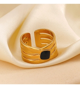 Macro shot of gold wide open ring featuring black enamel square on luxury satin background