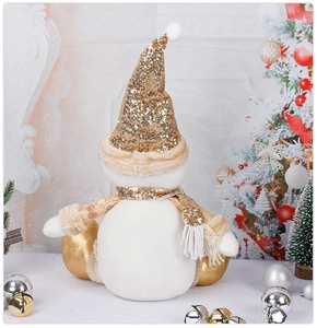 Close-up of sitting Christmas snowman plush with gold sequins and soft white fabric texture