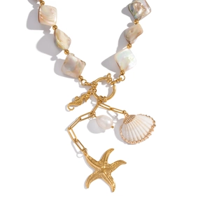 Detail of ocean-themed necklace with gold seahorse, seashell, and starfish charms