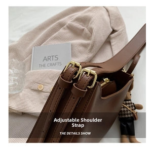Detail view of adjustable brown leather strap with polished golden metal buckles