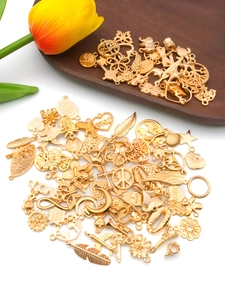 Flat lay of mixed KC gold alloy charms with heart and flower shapes for DIY jewelry