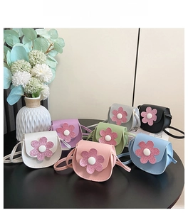 Detailed view of kids cute flower crossbody bags in seven colors on a table