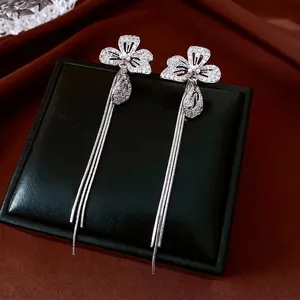 Elegant silver flower earrings with zircon pearls and long tassels on black jewelry box