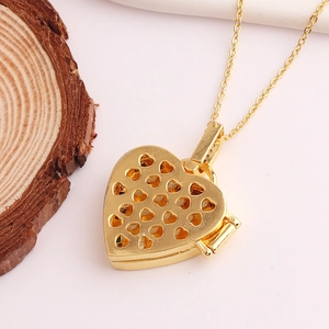 Macro shot of a golden heart locket necklace with hollow heart patterns on a wood slice