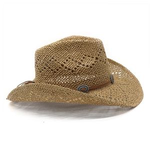 Close-up of hollowed-out straw cowboy hat with leather band and vintage metal studs