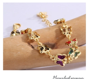 Detail of gold butterfly bracelet with colorful micro-inlaid zirconium on wood