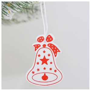 Detail of wooden Christmas bell ornament with red star print and white polka dot bow