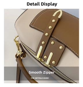 Détail de la fermeture éclair en métal et des rivets dorés sur le sac en cuir bicolore