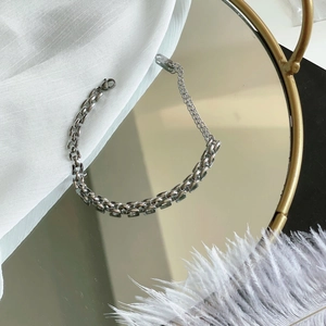 Sleek silver industrial chain bracelet on a mirrored surface with luxury styling