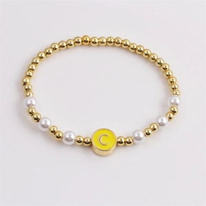Fashion beaded bracelet with gold copper beads, white pearls, and yellow moon enamel pendant