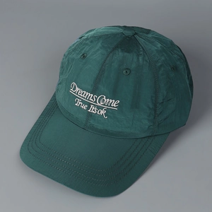 Close-up of white letter embroidery on dark green quick-dry baseball cap fabric
