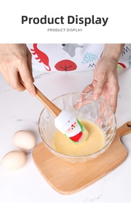Close-up of Santa Claus silicone spatula with wooden handle mixing eggs in a bowl