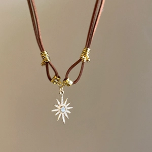 Detail of faux leather necklace with gold star pendant and sparkling rhinestones