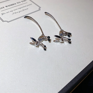 Detail view of fox-shaped silver needle stud earrings with black enamel on a gift card