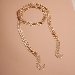 Detail of gold metal mesh long tassel necklace featuring sparkling rhinestones accents