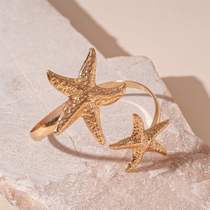 Macro detail of golden irregular starfish arm cuff with realistic textured metal finish