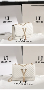 Detail of white quilted crossbody bag with golden V logo, tassel, and chain strap