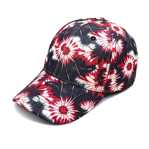 Detail of a tie-dye baseball cap featuring vibrant red and black floral patterns on cotton