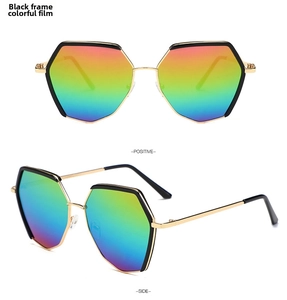 Detail view of hexagonal sunglasses with black frames, gold temples, and iridescent lenses