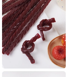 Macro detail of deep red twisted hawthorn candy strips with fresh hawthorn fruits