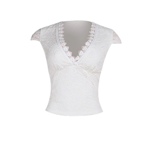Dettaglio dei complessi motivi in pizzo bianco e dello scollo a V su questo top elegante