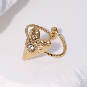 Goldener Edelstahlring mit Herzform, Hammerschlag-Textur und Zirkon auf weißem Stein
