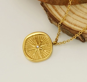 Macro shot of 18k gold plated eight-pointed star pendant on natural wood slice