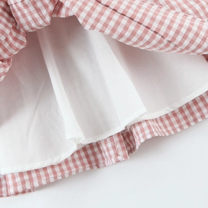 Pink and white plaid mini dress with puff sleeves and bow detail on a white background