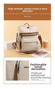 Close-up of cream textured leather backpack with brown zipper accents and tassel charm