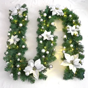 Close-up of 2.7m Christmas garland with white poinsettia, silver baubles and warm LED lights