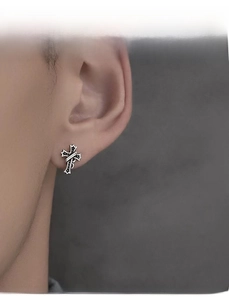 Close-up of vintage silver cross earring with gothic texture and antique finish for men