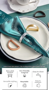 Detailed view of polished D-shaped metal napkin rings in gold, silver, and rose gold finishes
