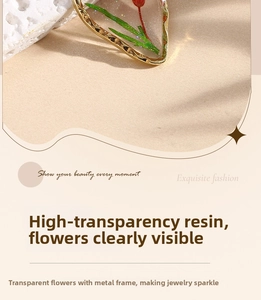Macro view of dried daisy heart earrings with clear resin and gold metal frame