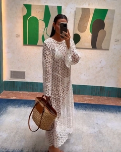 Detail of white crochet lace maxi dress paired with a brown patchwork straw bucket bag
