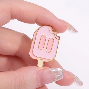 Broche en émail crème glacée rose avec bordure dorée et design mordu sur la main