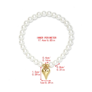 Detail view of pearl beaded bracelet with a golden heart pendant and size measurements
