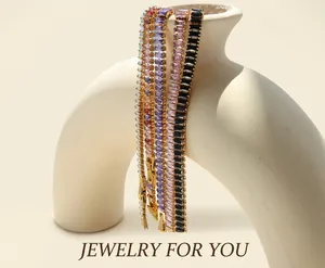 Detailed shot of gold plated tennis bracelets with colorful rectangular cut zircons on a vase